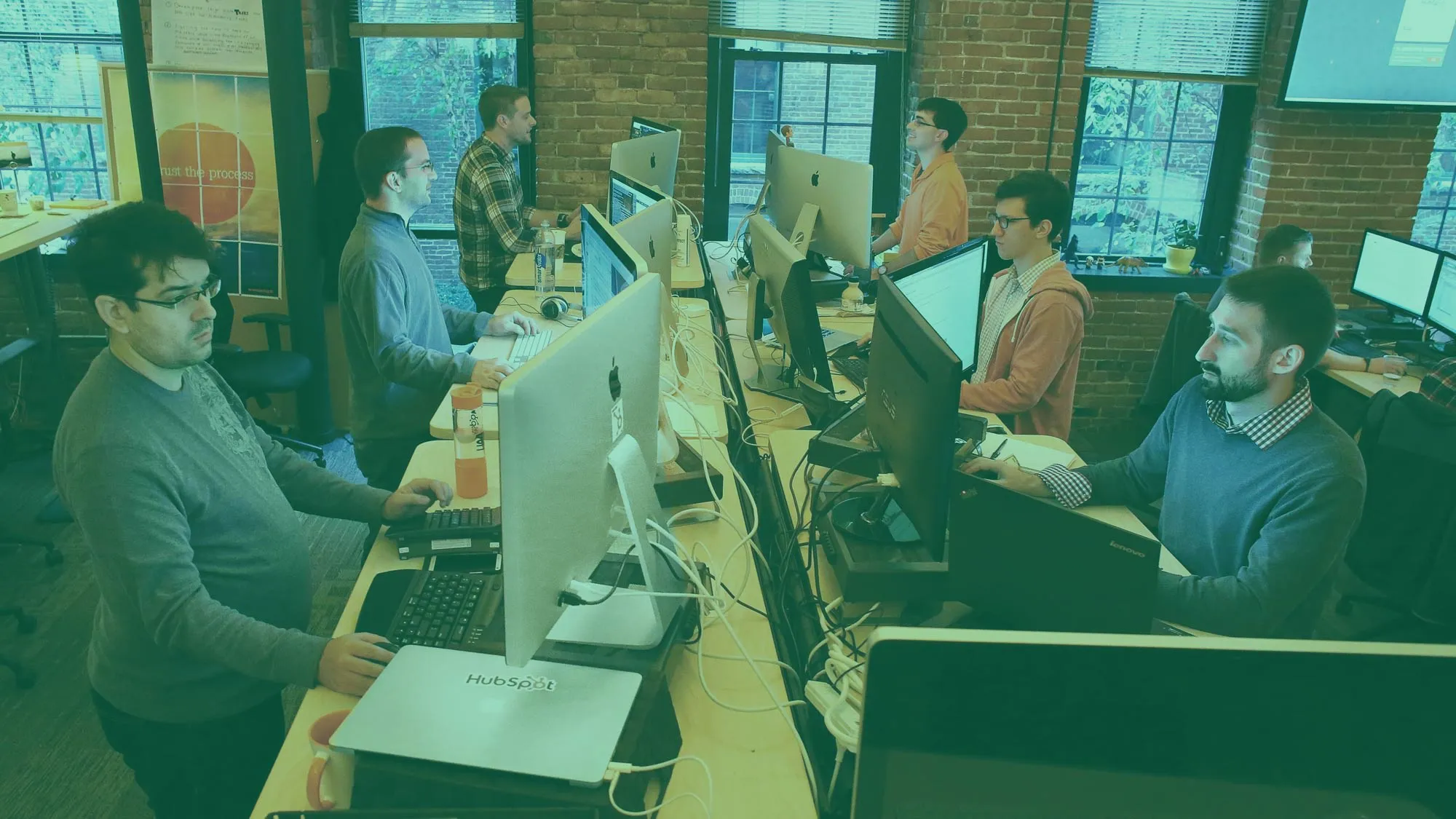 Tech entrepreneurs working on innovative software development with multiple monitors showing code and digital interfaces